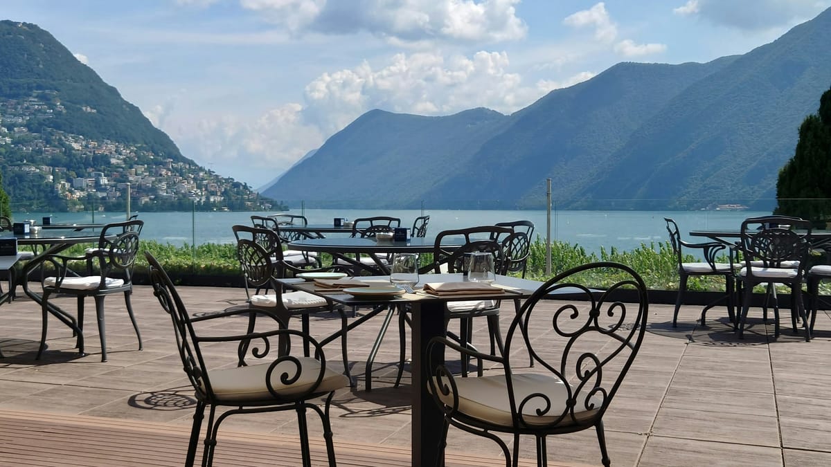 Gedeckte Tische mit Blick auf See und Berge